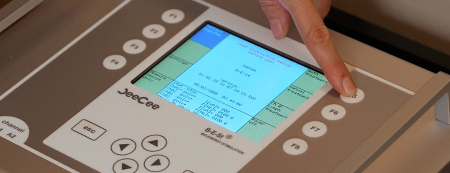 Close-up of the B-E-St microcurrent therapy device displaying treatment settings for cellular repair, ATP production, and muscle recovery in Dubai.