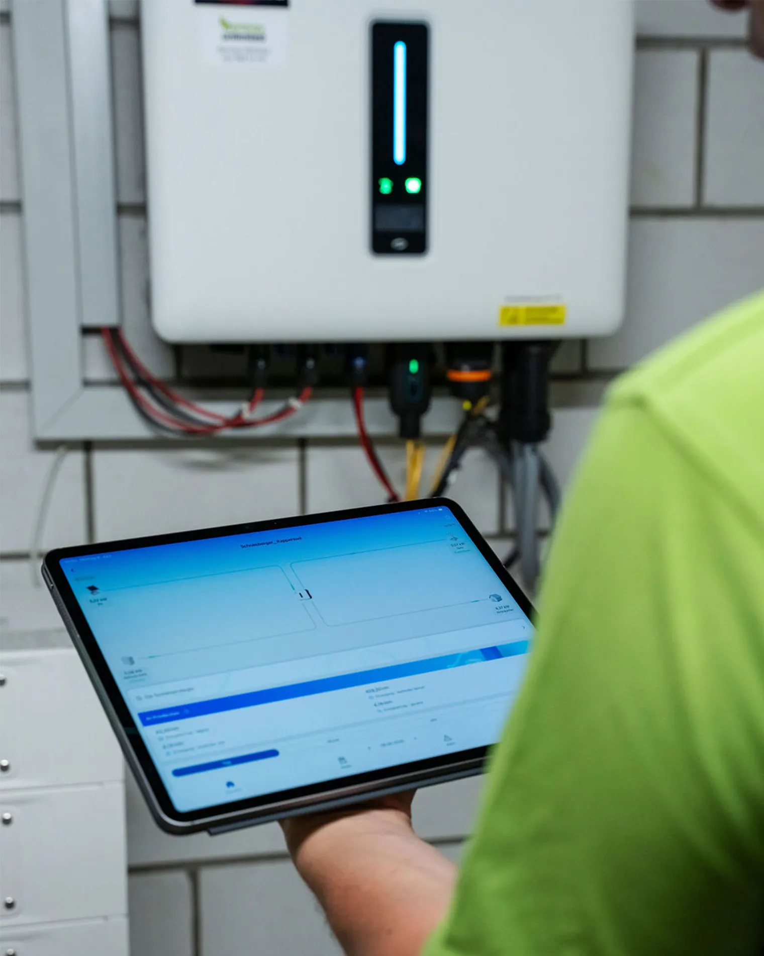 Ein Mitarbeiter checkt den Stromverbrauch und den Eigenverbrauch auf dem Tablet