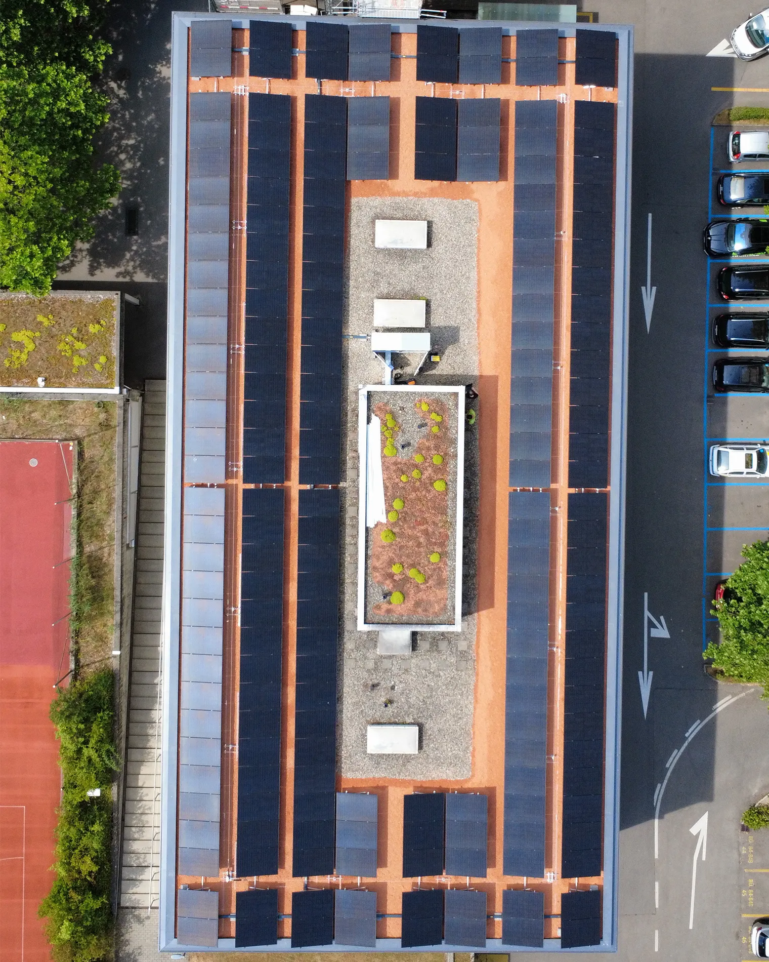 Von oben Fotografiertes Firmengebäude mit einer Photovoltaikanlage auf dem Dach