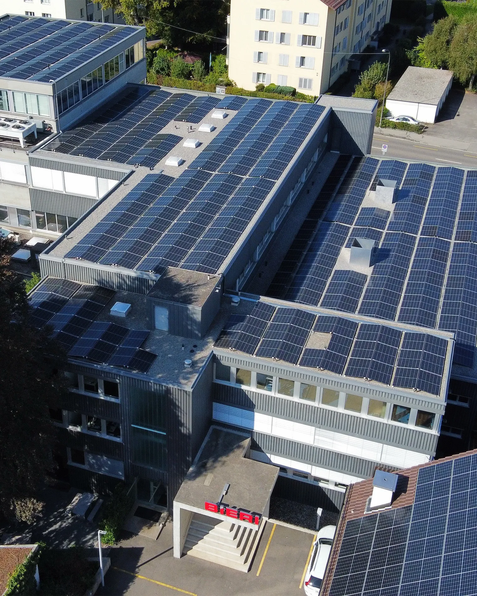 Drohnenaufnahme eines Firmengebäude mit einer Photovoltaikanlage