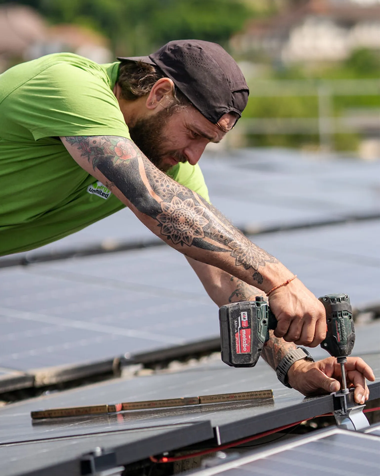 Mitarbeiter von energy unlimited AG bringt ein Solarpanel auf einem Flachdach an.