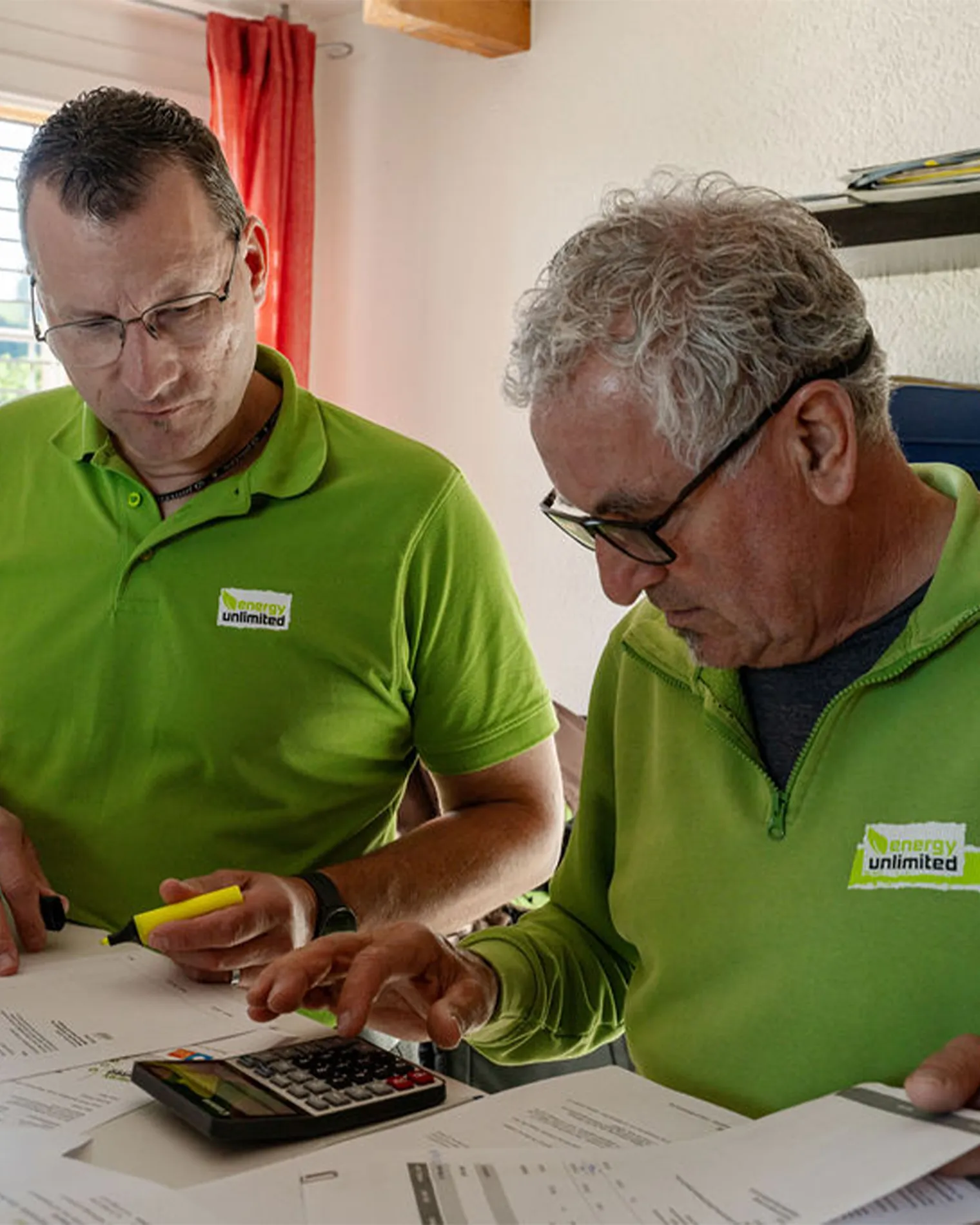Zwei Mitarbeitenden von energie unlimited planen und berechnen die Wirtschaftlichkeit einer PV-Anlage mit Stromspeicher