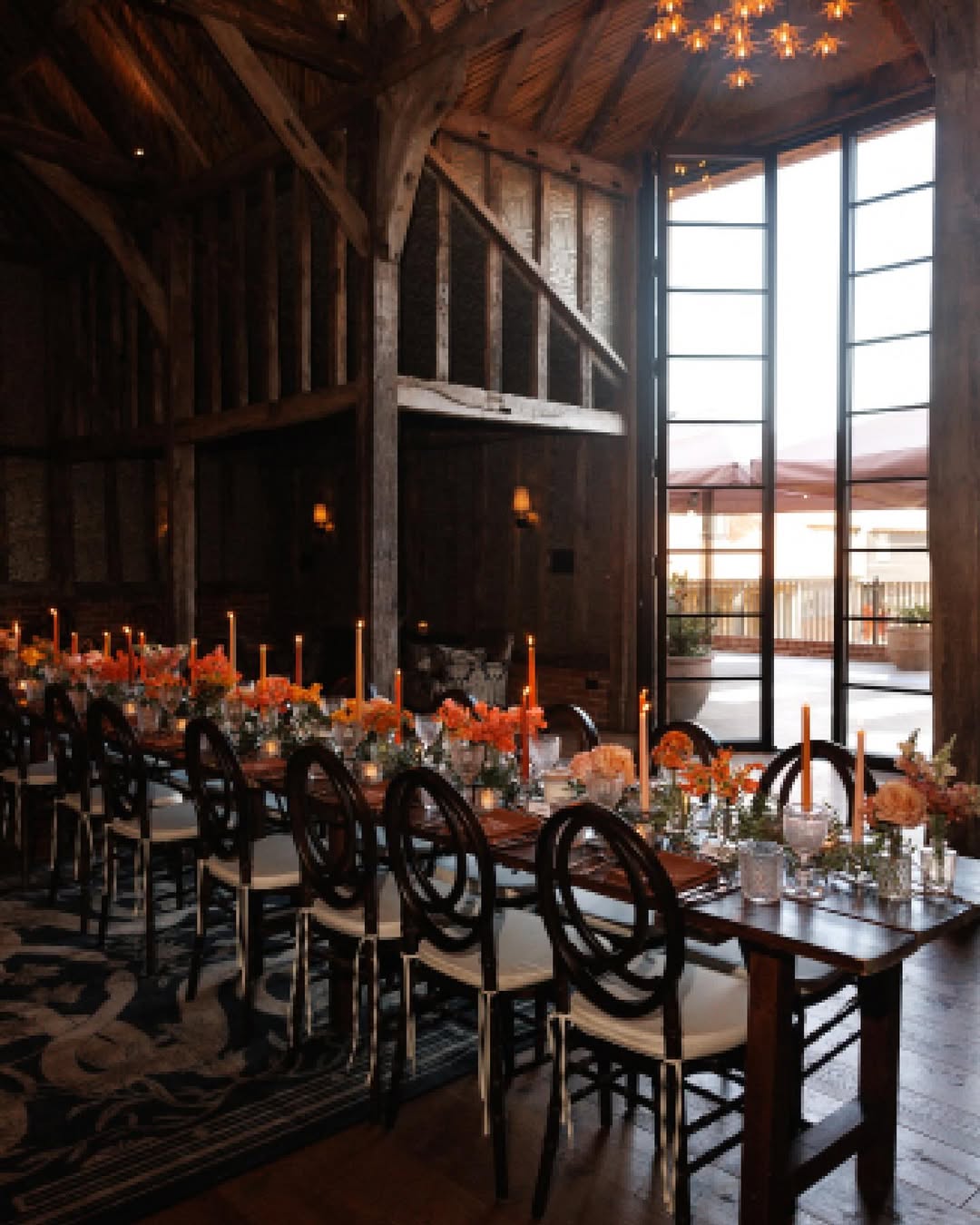 Elegant outdoor dining table setup with candles and floral centerpieces at a Sweaty Betty wellness retreat.