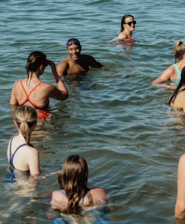 Members of Speedo Outsiders Club enjoying a social open-water swim together under clear skies.