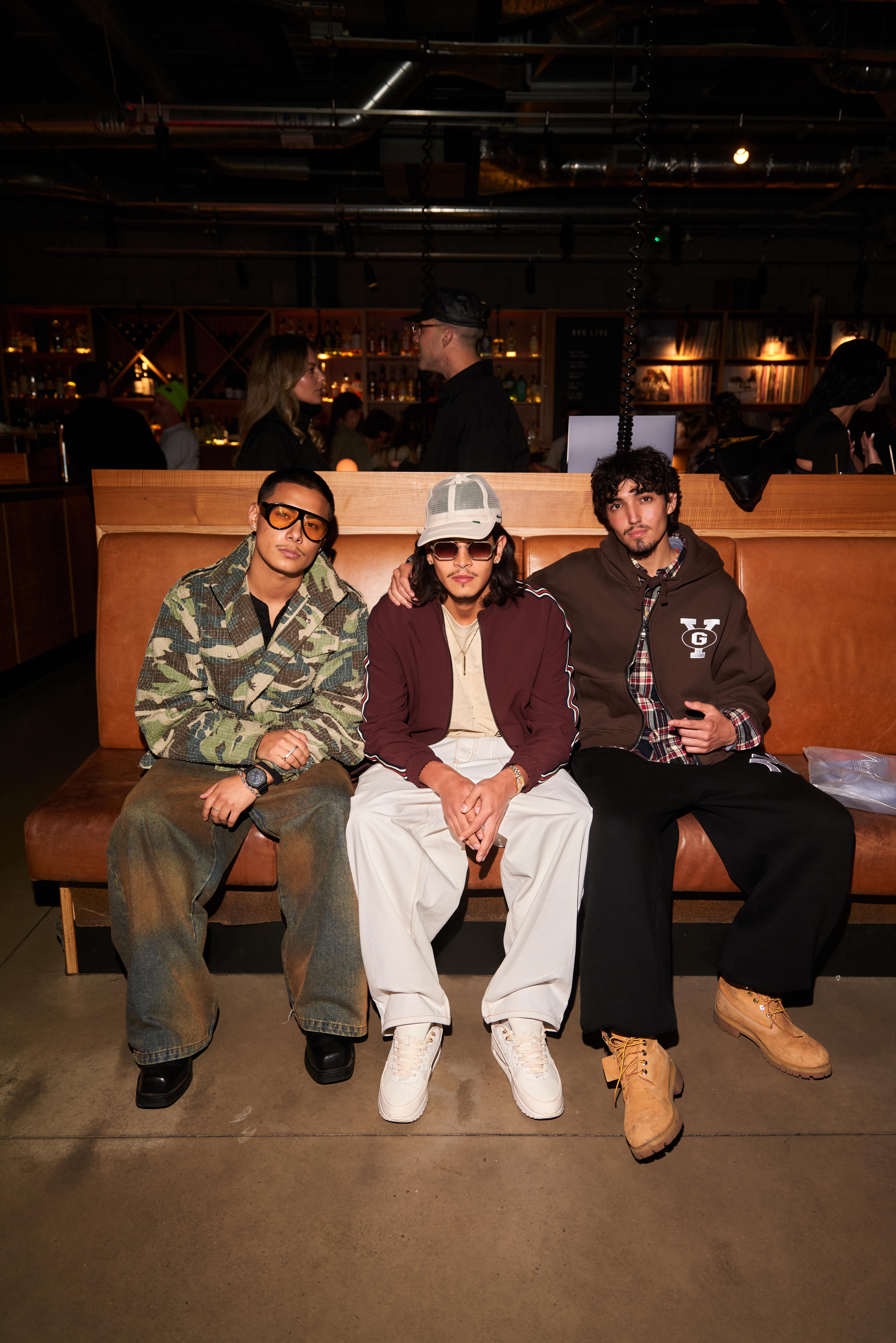 Three guests dressed in streetwear outfits posing together at AVX Live event.