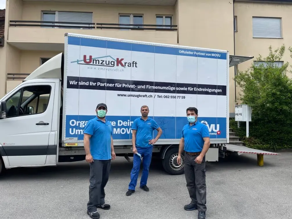 Drei Mitarbeiter von UmzugKraft vor einem Umzugswagen