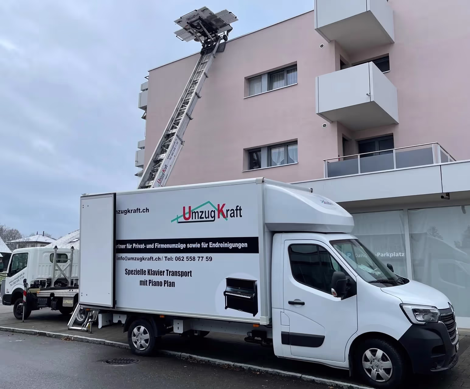 Umzugswagen von UmzugKraft mit Möbellift vor einem Mehrfamilienhaus