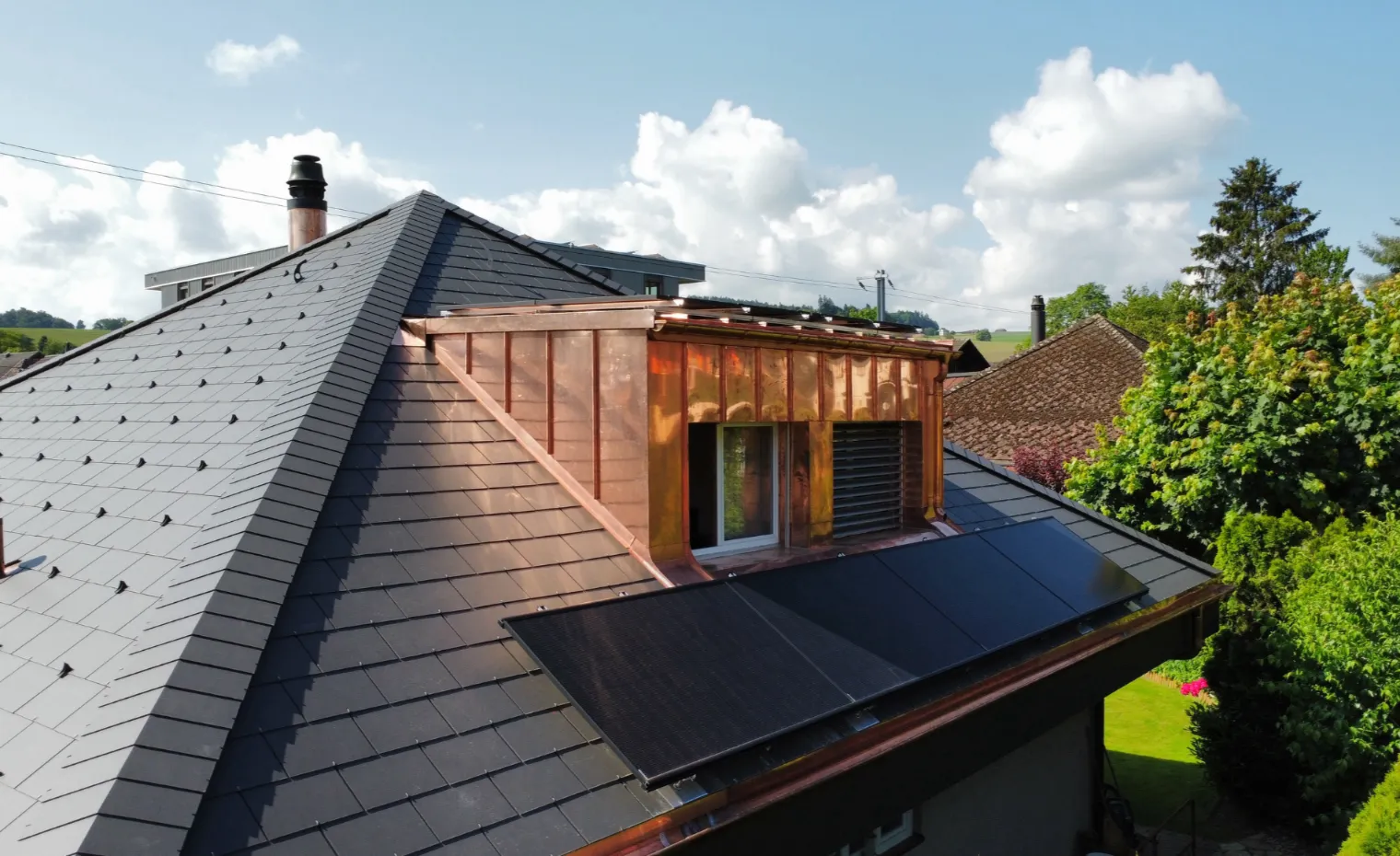 Hausdach mit neuer Photovoltaikanlage und Kupfergaube
