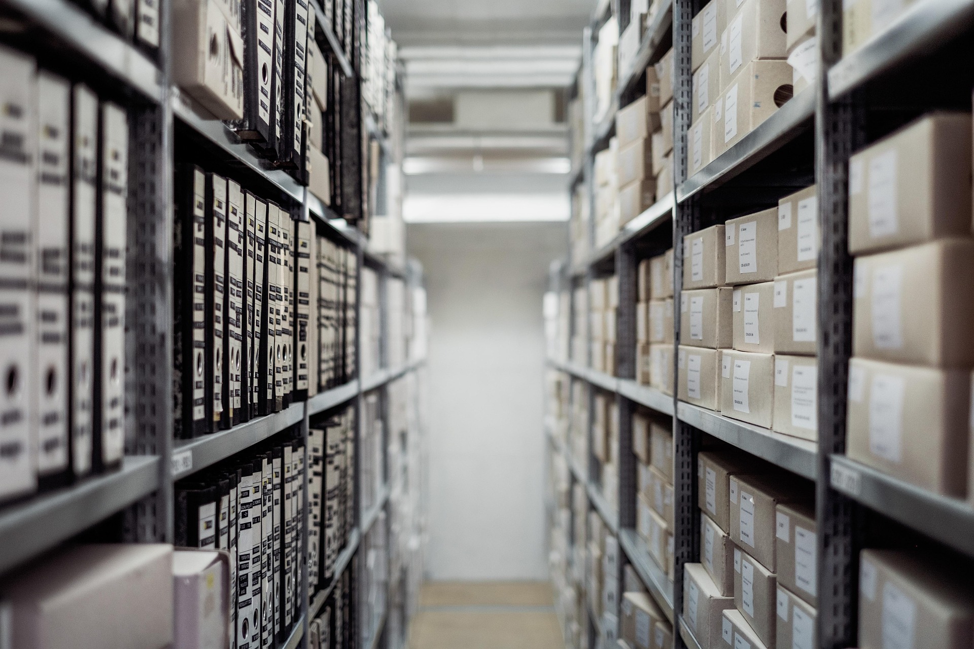Densely stocked warehouse shelving with labelled inventory boxes, representing the complex stock management challenges facing retail warehouses during major demand spikes like the 2026 FIFA World Cup.