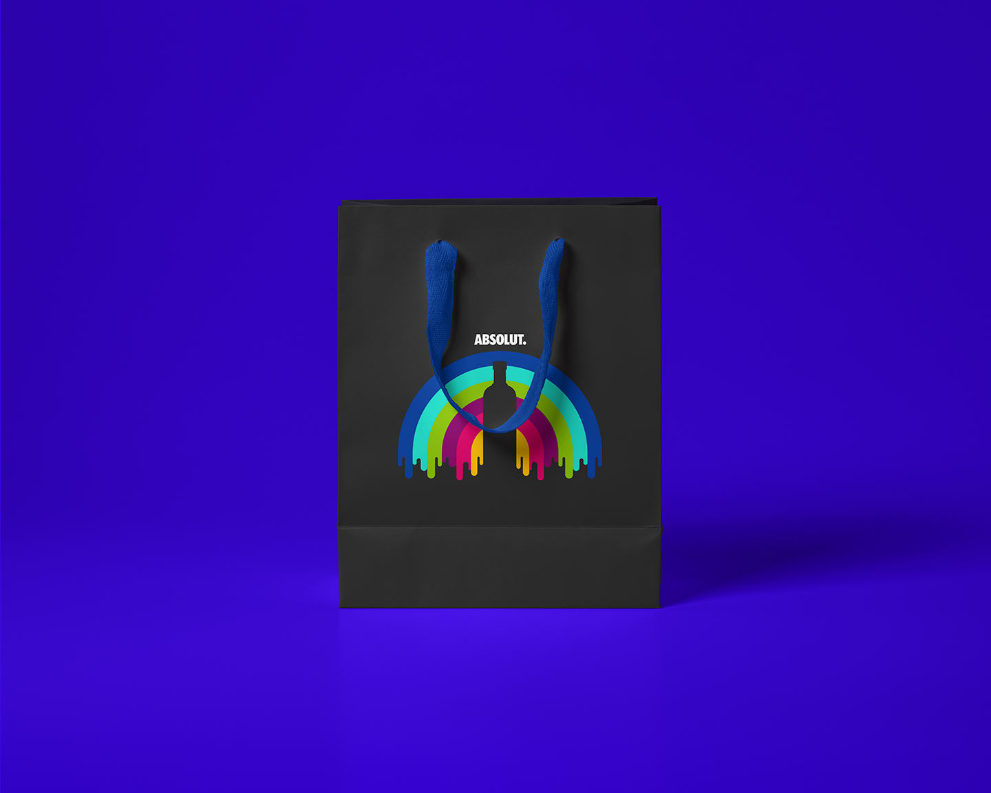 Black gift bag with blue handles featuring a colorful dripping rainbow and a silhouette of a bottle with the word Absolut above it.