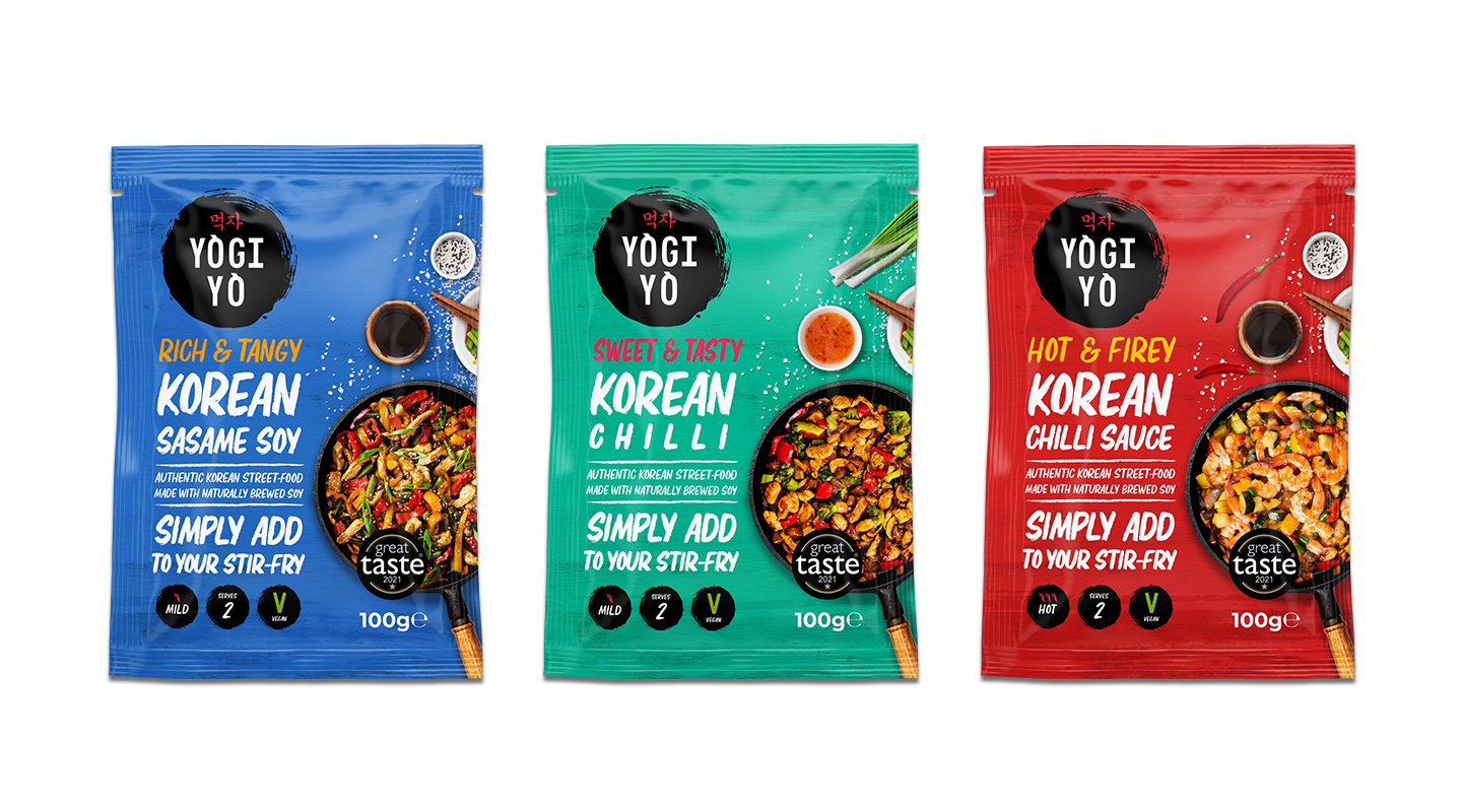 Three colorful packets of Yogi Yo Korean stir-fry sauces: blue Korean Sesame Soy, green Korean Chilli, and red Korean Chilli Sauce, each 100g and vegan.