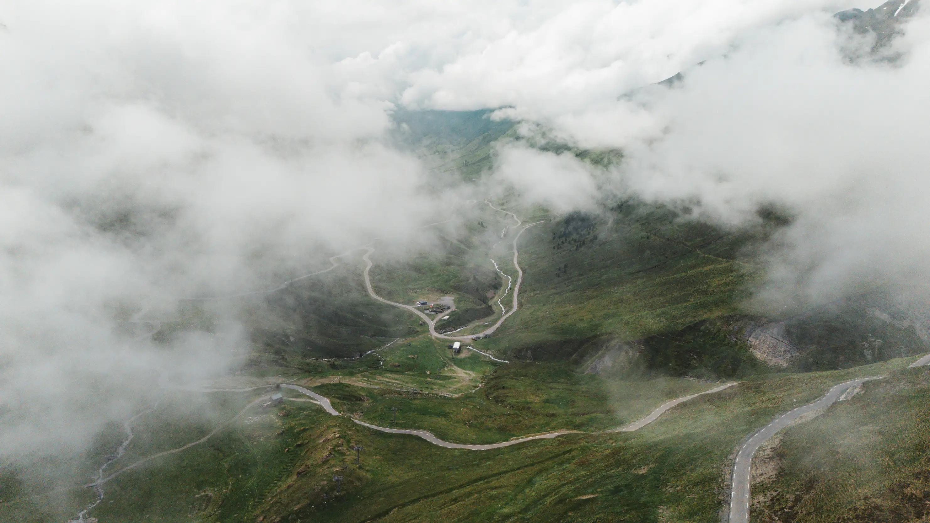 Route sinueuse du col du Tourmalet vue du ciel entre les nuages, versant de Barèges dans les Pyrénées