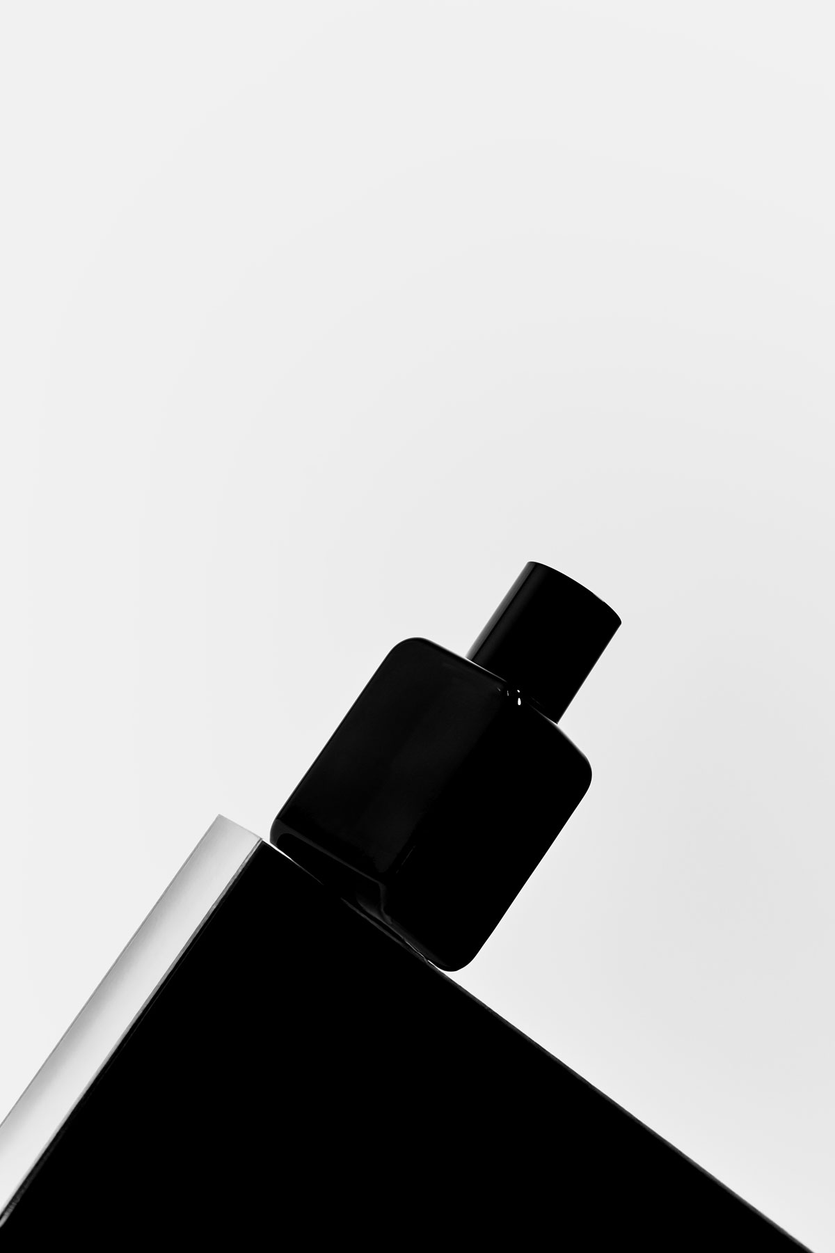 Minimalist black perfume bottle design by Dee April Parfums, photographed against a white background for our story section.