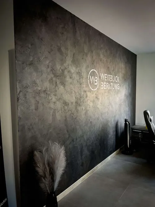 A wall with a logo and a gray background.