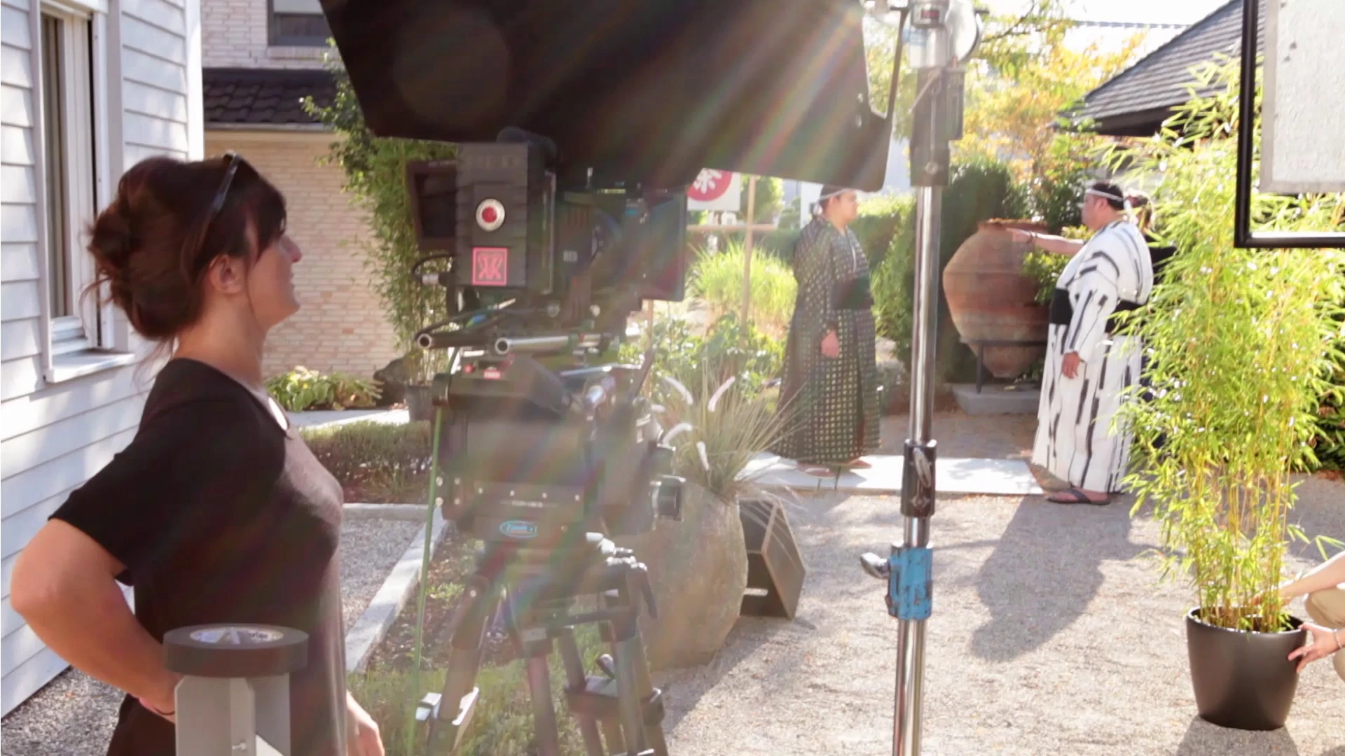 Werbefilm der Filmproduktion Panda Pictures aus München für BMW Connected Drive. Eine Kamerafrau steht hinter der Filmkamera, die auf zwei Darsteller in traditionellen japanischen Gewändern gerichtet ist, die im Garten interagieren.