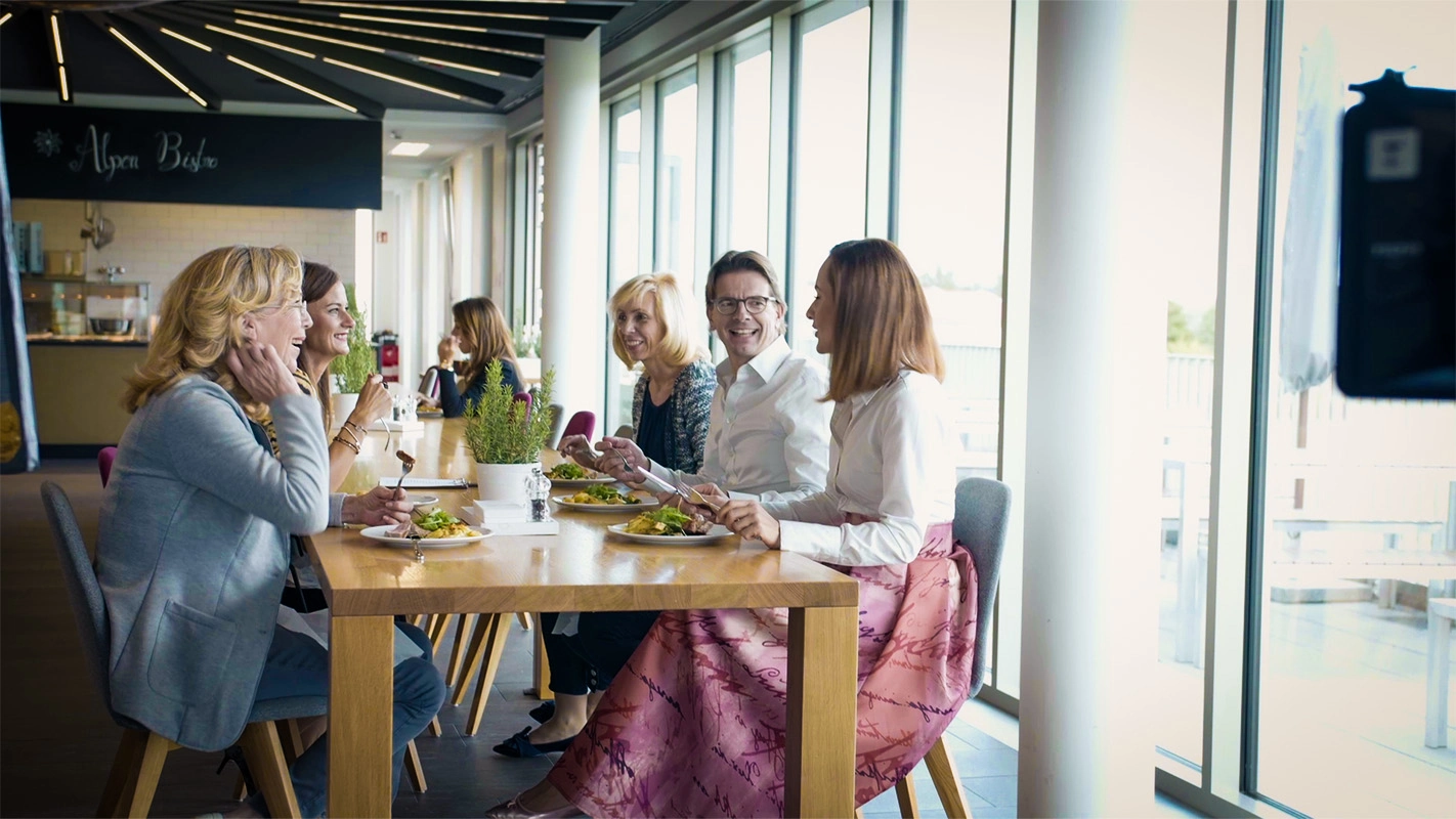 Recruitingfilm der Filmproduktion Panda Pictures aus München und Ulm für Reviderm. Gruppenszene für Employer Branding Zwecke. Mitarbeiter von Reviderm sitzen in entspannter Atmosphäre an eine, großen langen Tisch.