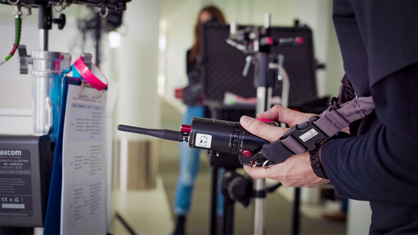 Recruitingfilm der Filmproduktion Panda Pictures aus München und Ulm für Reviderm. Detailaufnahme der Hand des Kameraassistenten, der die Schärfe zieht, im Hintergrund weitere Crewmitglieder. Making-Of eines Recruitngfilms.