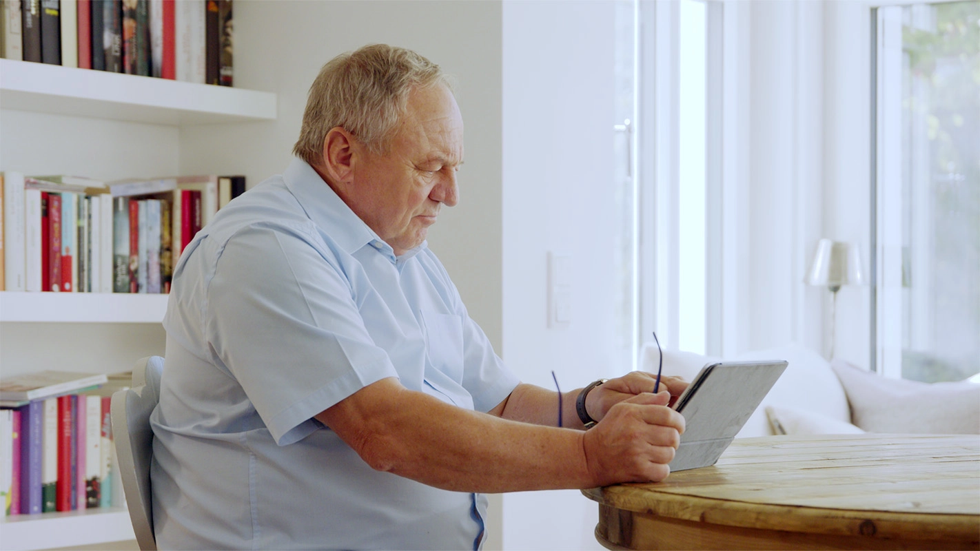 Erklärfilm der Filmproduktion Panda Pictures aus München und Ulm für Landesanstalt für Kommunikation. Ein Darsteller sitzt konzentriert an einem Tisch und hält ein Tablet, was eine natürliche Filmaufnahme kreiert.