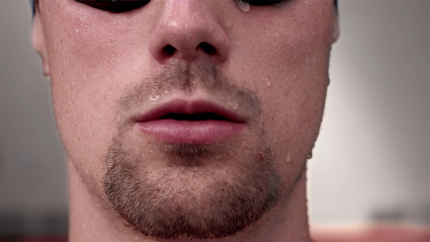 Imagefilm der Filmproduktion Panda Pictures aus München und Ulm für Speedo. Eine eindringliche Nahaufnahme des Gesichts eines Athleten mit Wassertropfen, detailreich inszeniert für eine emotionale Wirkung im Film.