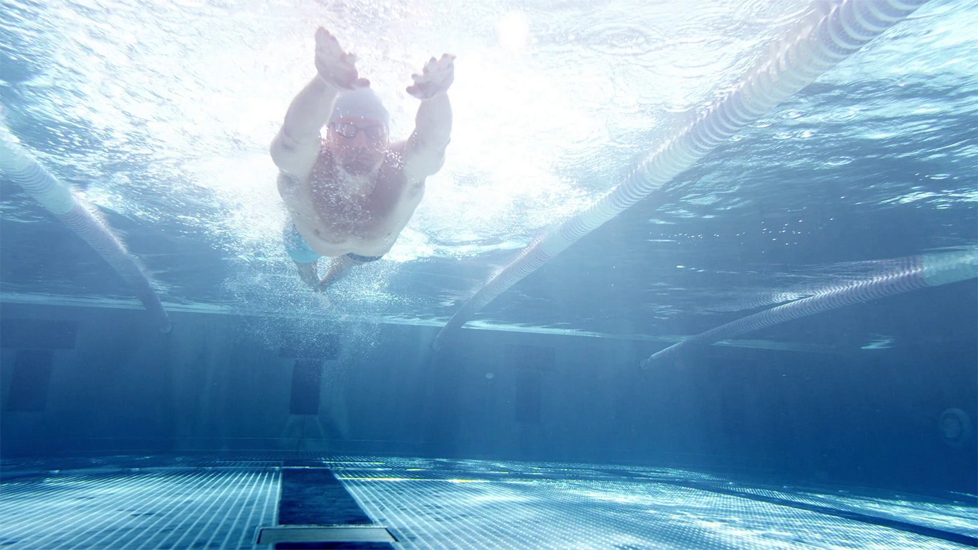 Imagefilm der Filmproduktion Panda Pictures aus München und Ulm für Speedo. Eine Unterwasser-Weitwinkelaufnahme zeigt einen Schwimmer, der in das Becken eintaucht, eine actionreiche Szene voller Dynamik.