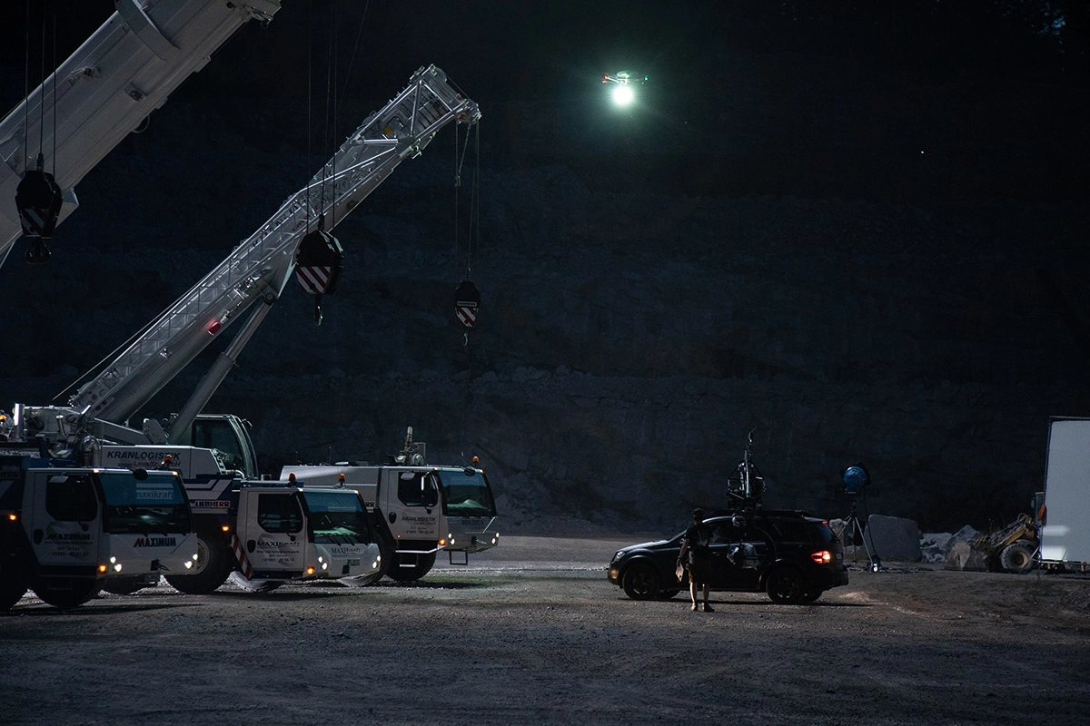 Imagefilm der Filmproduktion Panda Pictures aus München und Ulm für Maxikraft. Ein Kran, Lastwagen und ein Kamerateam sind bei Nacht in einer Kiesgrube für die Dreharbeiten dieses Industriefilms positioniert.