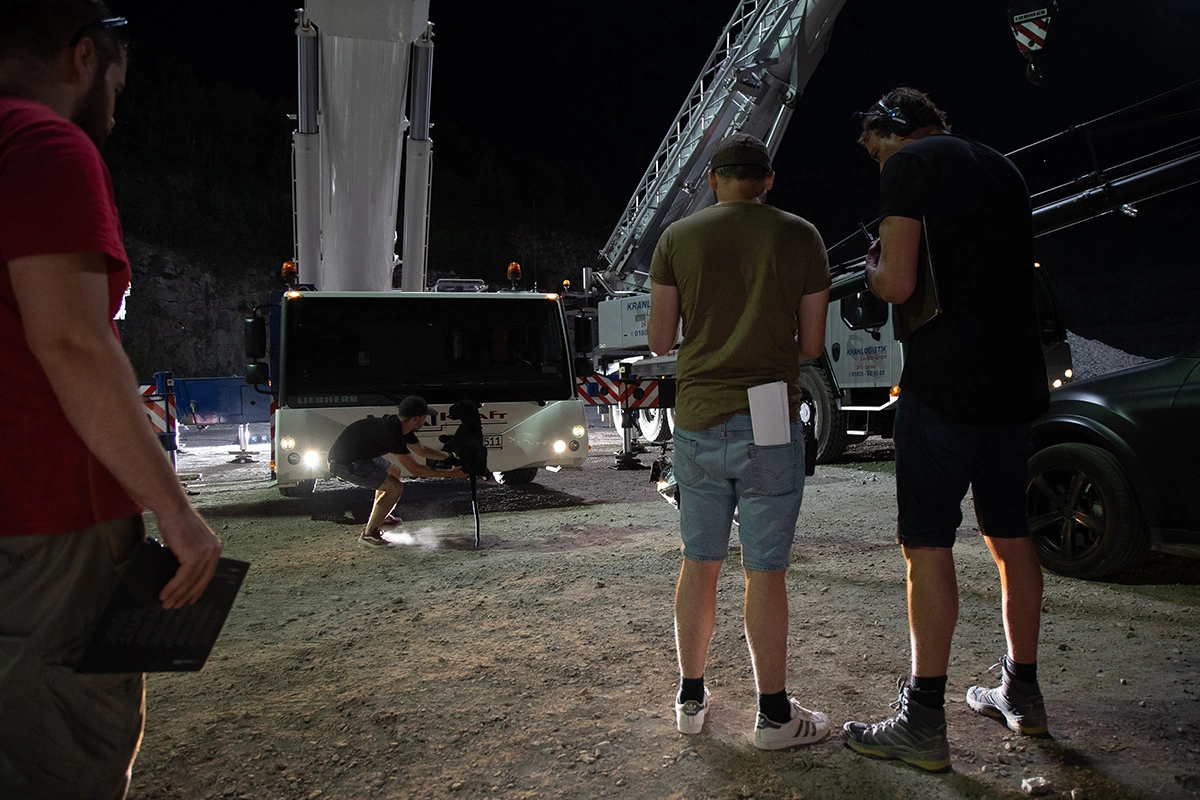 Imagefilm der Filmproduktion Panda Pictures aus München und Ulm für Maxikraft. Ein Beleuchter oder Oberbeleuchter platziert Lichter vor einem Maxikraft-LKW, während das Produktionsteam die nächtliche Szene vorbereitet.