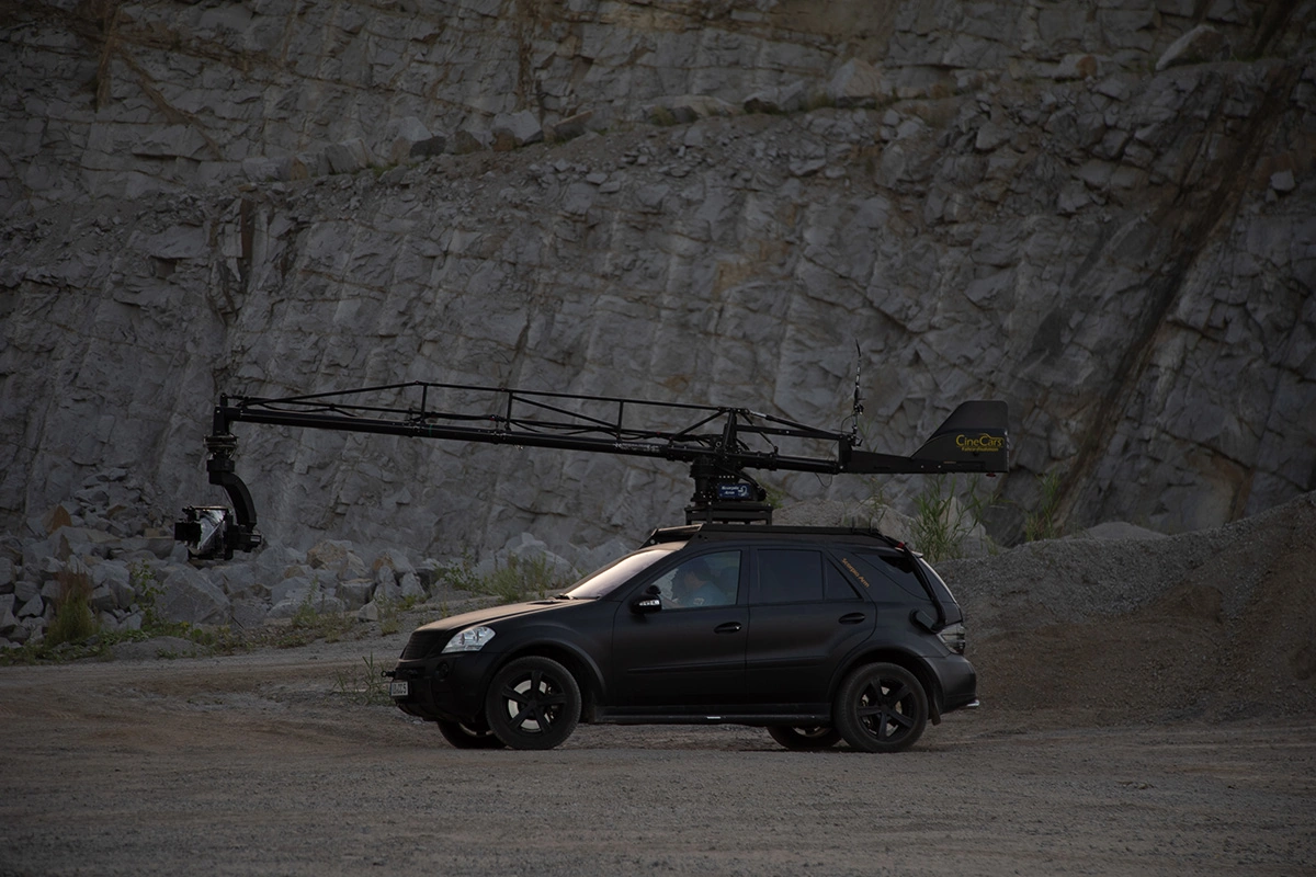 Imagefilm der Filmproduktion Panda Pictures aus München und Ulm für Maxikraft. Ein CineCar, ausgestattet mit einem Kamerakran, steht vor einer Felswand bereit für dynamische Fahrten in der Filmproduktion.