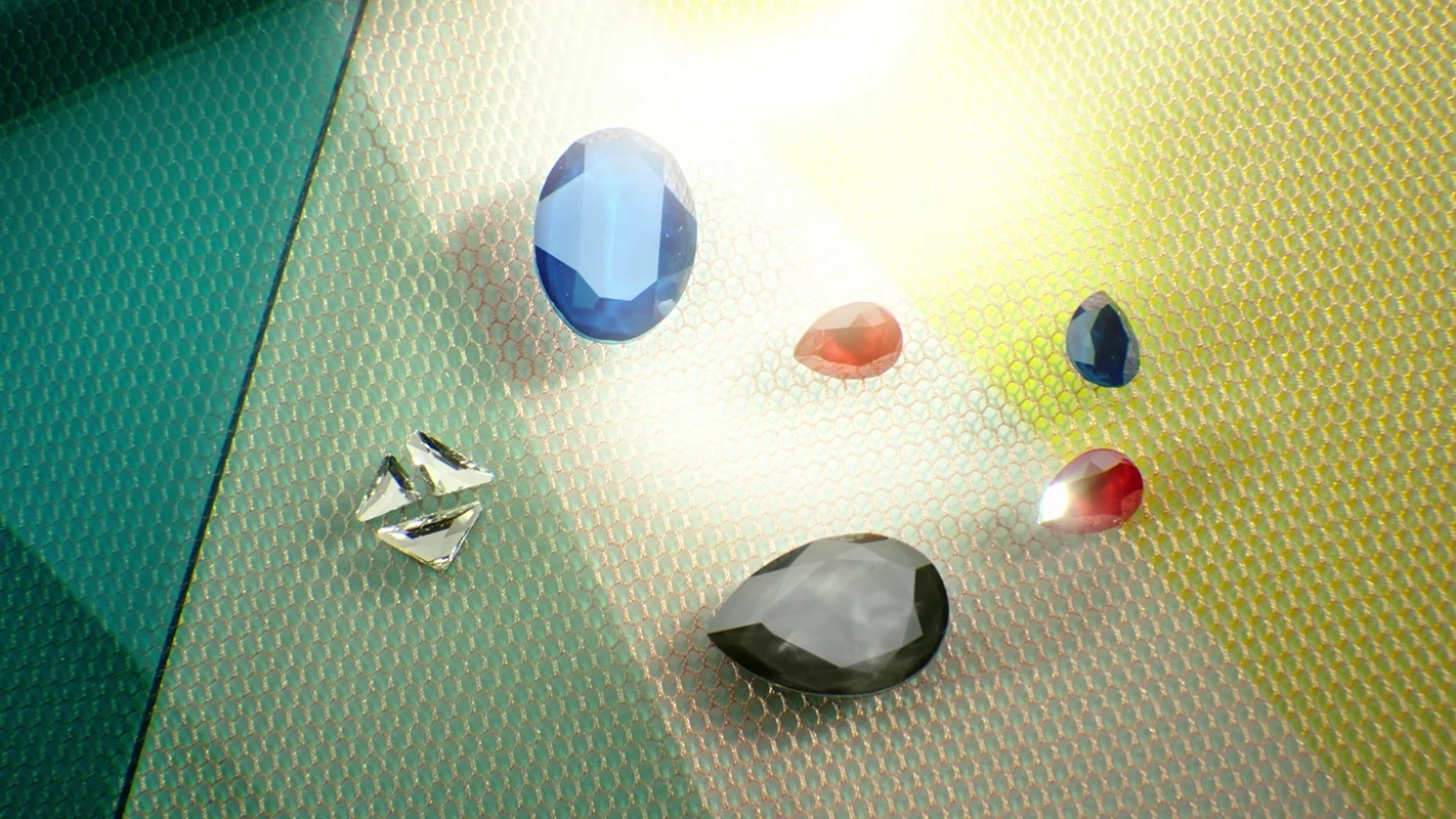 Filmproduktion Panda Pictures aus München und Ulm. Imagefilm von Swarovski. Eine Anordnung von Kristallen in verschiedenen Farben und Formen auf einem Netzgewebe, kunstvoll arrangiert und ausgeleuchtet.