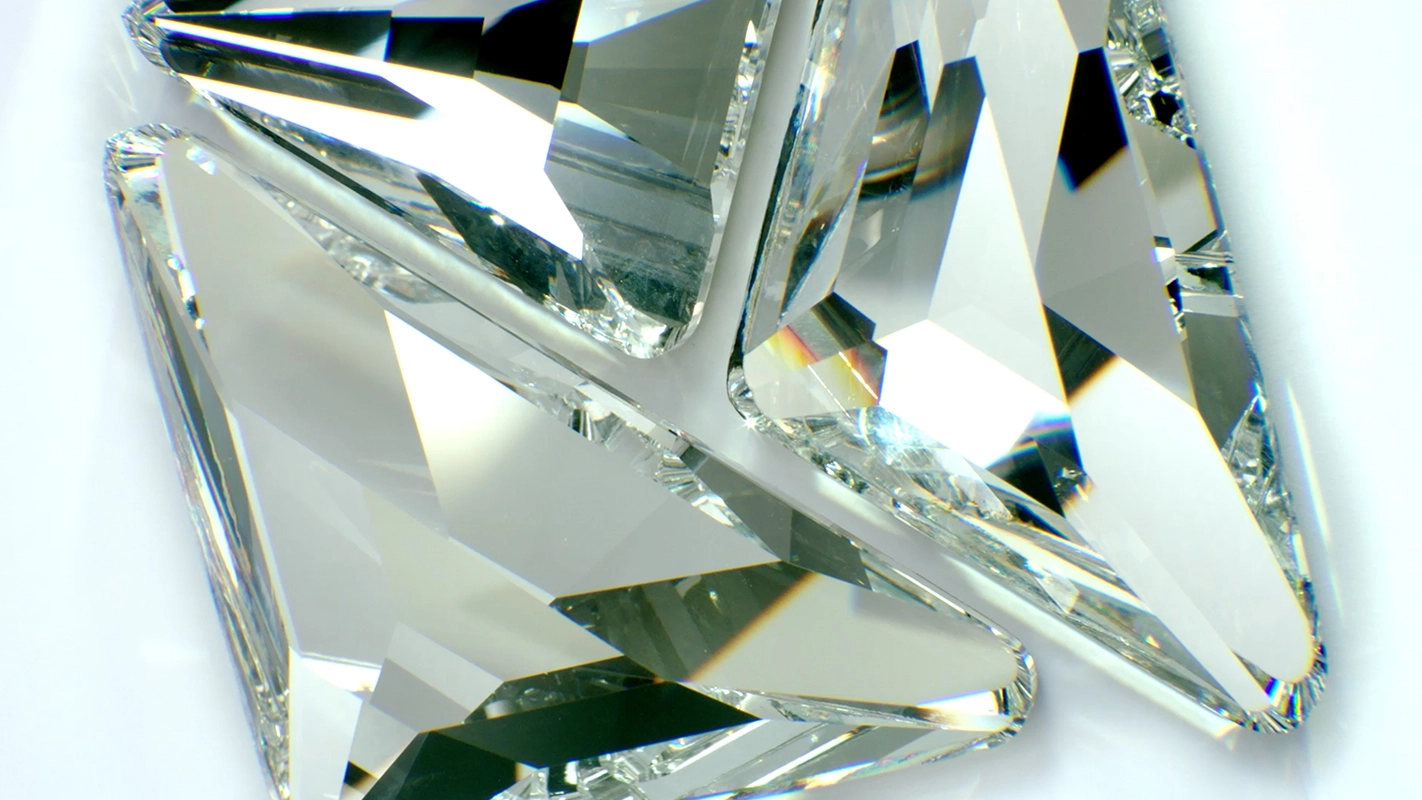 01-Filmproduktion Panda Pictures aus München und Ulm. Imagefilm von Swarovski. Eine Nahaufnahme zeigt funkelnde, facettenreiche Kristalle auf hellem Hintergrund, perfekt ausgeleuchtet für Hochglanzaufnahmen.