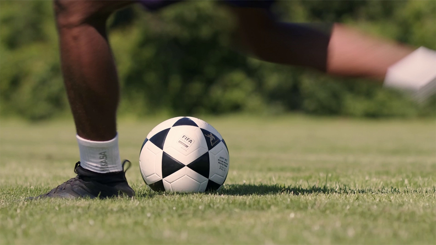 Produktfilm der Filmproduktion Panda Pictures aus München und Ulm für Hammer Sport. Nahaufnahme eines Fußballspielers, der den Ball am Fuß führt, detaillierte Aufnahme der Sportschuhe und des Balls.