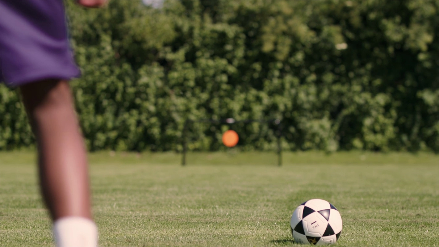 Produktfilm der Filmproduktion Panda Pictures aus München und Ulm für Hammer Sport. Ein Fußball liegt am Boden, im Anschnitt sieht man die Beine eines Spielers bereit zum Schuss. Dynamische Perspektive.