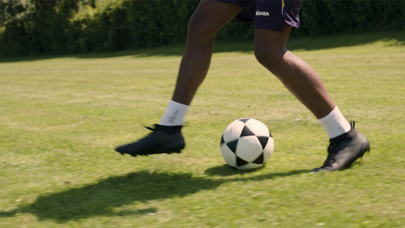 Produktfilm der Filmproduktion Panda Pictures aus München und Ulm für Hammer Sport. Ein Fußballspieler dribbelt den Ball über den Rasen, dynamische Kameraführung auf Fußhöhe für immersive Aufnahmen.