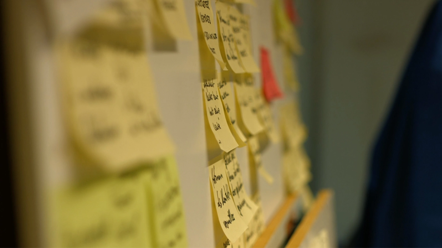 Imagefilm der Filmproduktion Panda Pictures aus München und Ulm für TechFounders. Ein ungeschnittenes Detail zeigt eine Wand voller gelber Post-its, die Notizen und Ideen festhalten, im Hintergrund leicht unscharf.
