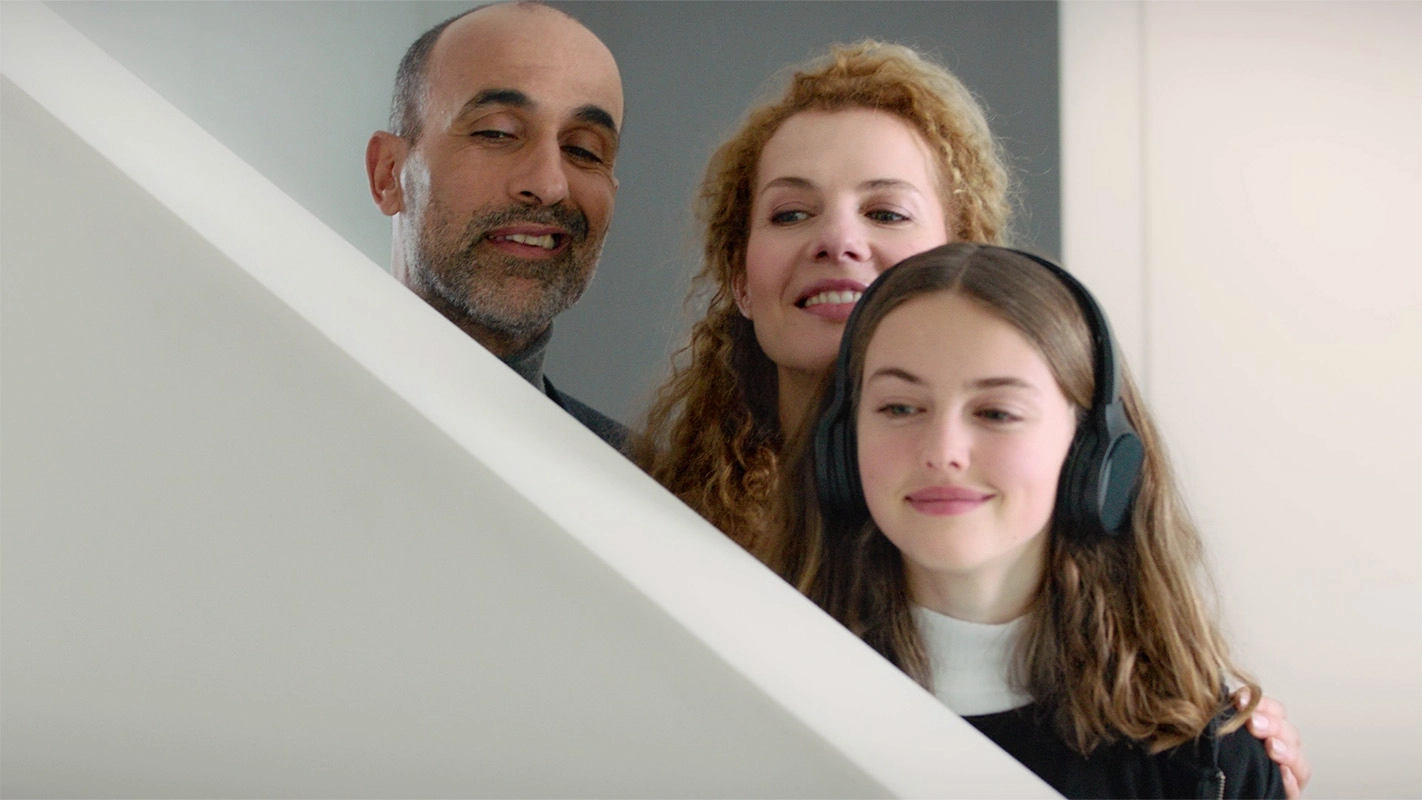 Imagefilm der Filmproduktion Panda Pictures aus München und Ulm für GIRA. Eine Familie mit Vater, Mutter und Tochter, die Kopfhörer trägt, blickt gemeinsam nach oben. Die Darsteller wirken interessiert.