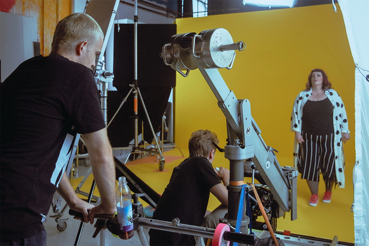 Produktfilm der Filmproduktion Panda Pictures aus München und Ulm für Juzo. Drei Filmteam-Mitglieder besprechen die Szene am Set, hinterleuchtet von professioneller Filmbeleuchtung. Produktfilm der Filmproduktion Panda Pictures aus München und Ulm für Juz