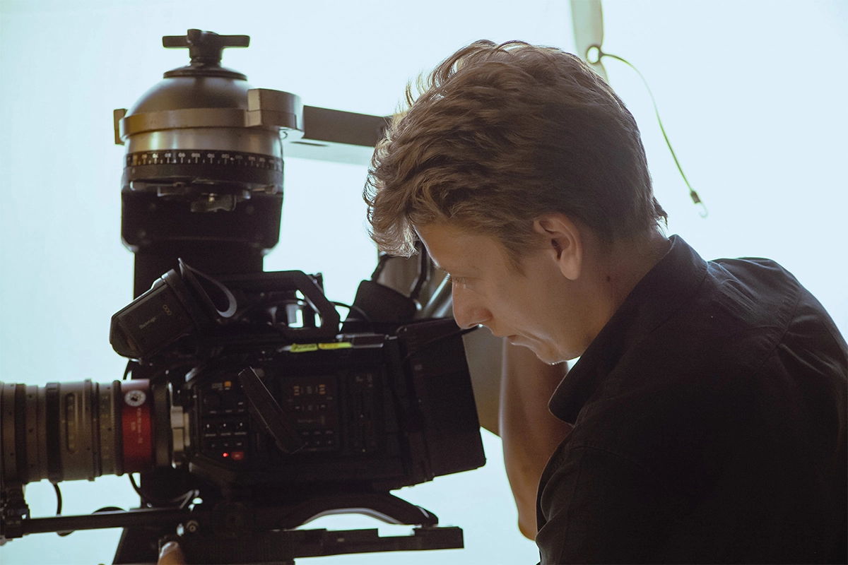 Produktfilm der Filmproduktion Panda Pictures aus München und Ulm für Juzo. Ein Kameramann konzentriert sich auf die Einstellung durch den Sucher der Filmkamera.