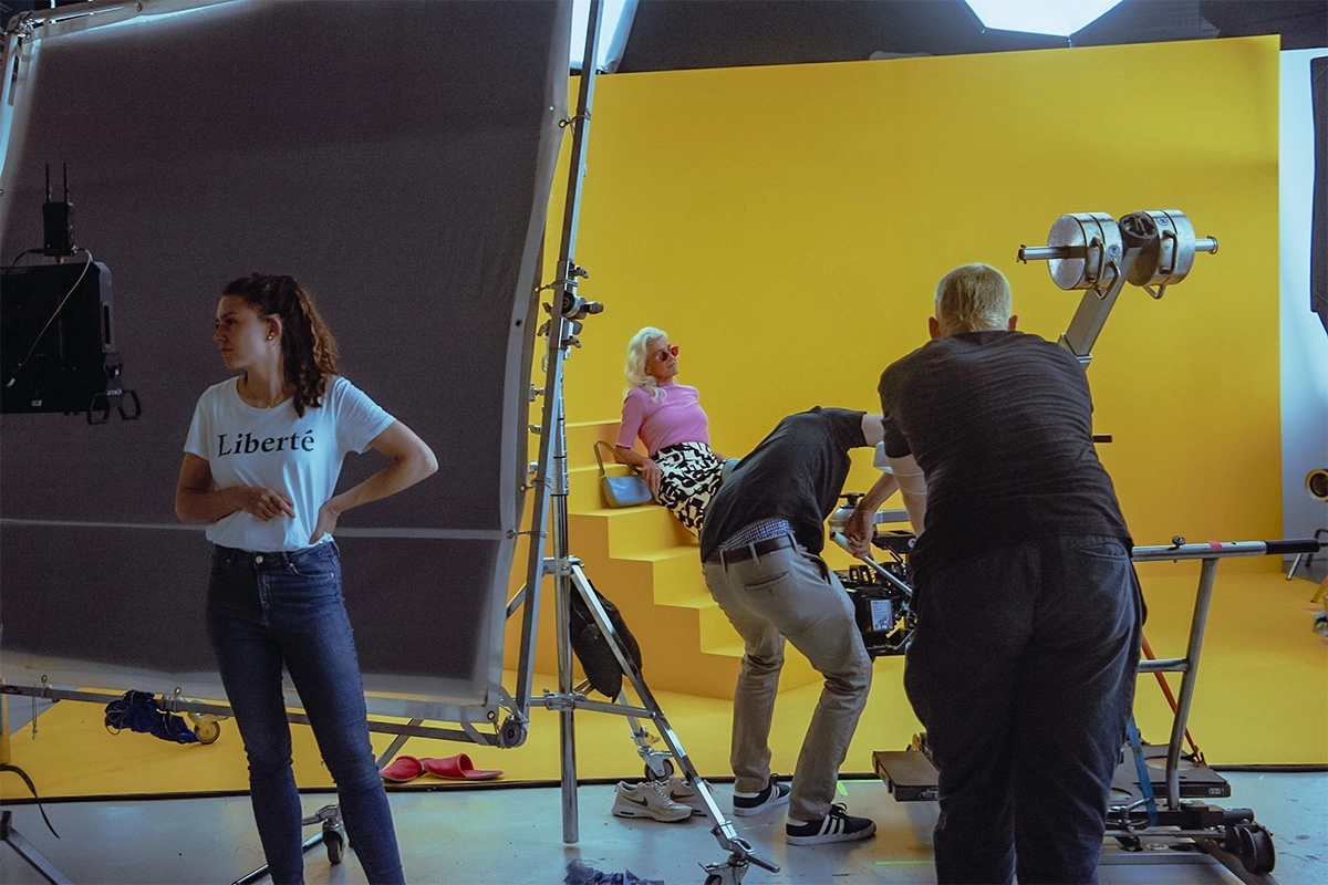 Produktfilm der Filmproduktion Panda Pictures aus München und Ulm für Juzo. Eine Darstellerin in T-Shirt und Jeans wartet auf ihren Einsatz, während Crewmitglieder am Set agieren.
