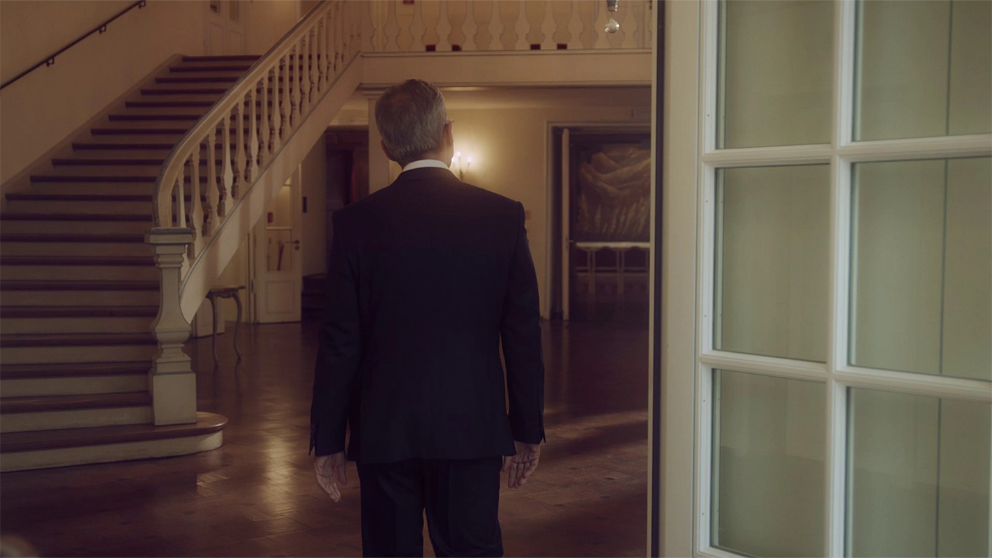 Weihnachtsfilm der Filmproduktion Panda Pictures aus München und Ulm für UniCredit. Der Protagonist betritt einen Raum mit einer geschwungenen Treppe, eine Szene, die zum Setting des Weihnachtsfilms passt.