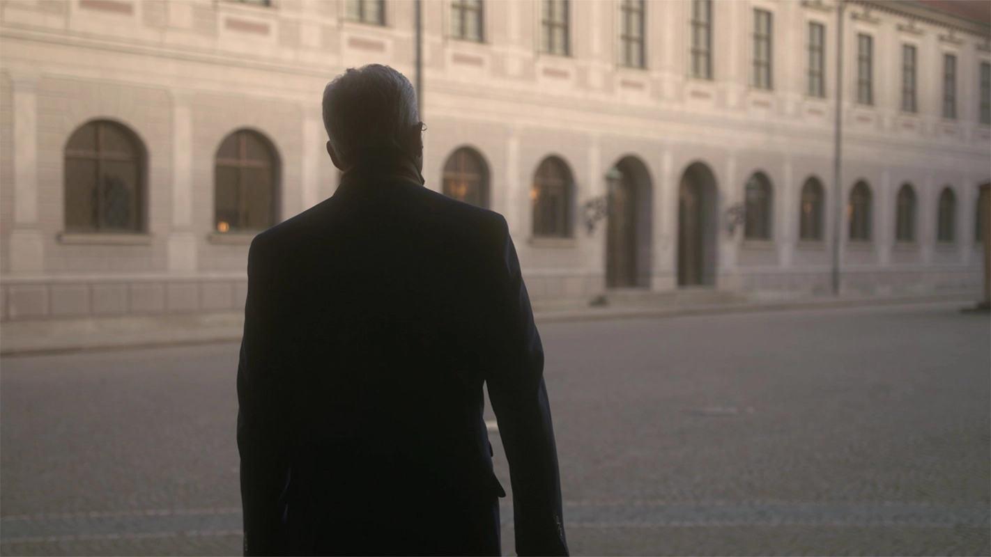 Weihnachtsfilm der Filmproduktion Panda Pictures aus München und Ulm für UniCredit. Ein Protagonist in dunklem Anzug von hinten, der auf ein historisches Gebäude zuläuft, eine einleitende Einstellung für die dokumentarische Videoproduktion.