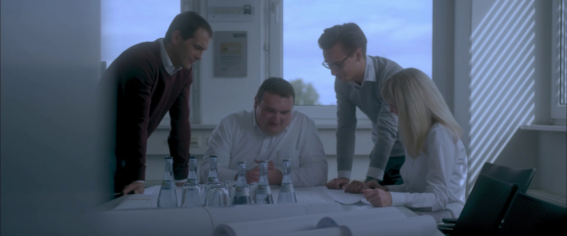Imagefilm der Filmproduktion Panda Pictures aus München und Ulm für HARDER. Vier Darsteller besprechen Baupläne an einem Tisch, Licht fällt durch Jalousien. Eine authentische Momentaufnahme aus einem Meeting.