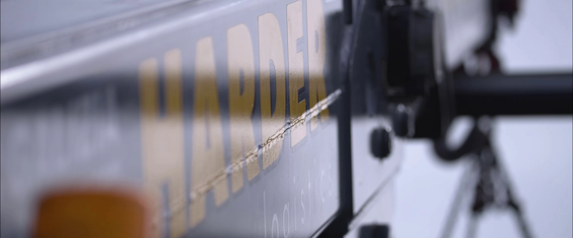 Imagefilm der Filmproduktion Panda Pictures aus München und Ulm für HARDER. Detailaufnahme auf das Harder-Logo auf einem LKW, die Perspektive unterstreicht die Größe der Produktion.
