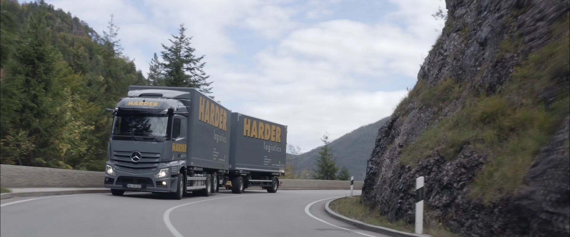 Imagefilm der Filmproduktion Panda Pictures aus München und Ulm für HARDER. Ein Harder-Lkw fährt auf einer Bergstraße. Die Drohnenaufnahme betont die Erhabenheit der Landschaft.