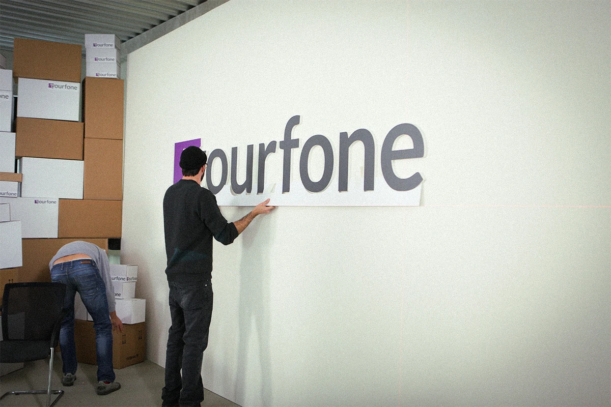 TV Werbespot der Filmproduktion Panda Pictures aus München und Ulm für yourfone. Ein Set-Designer bringt das yourfone-Logo an der Wand an, während die Kulisse für die Szene vorbereitet wird.