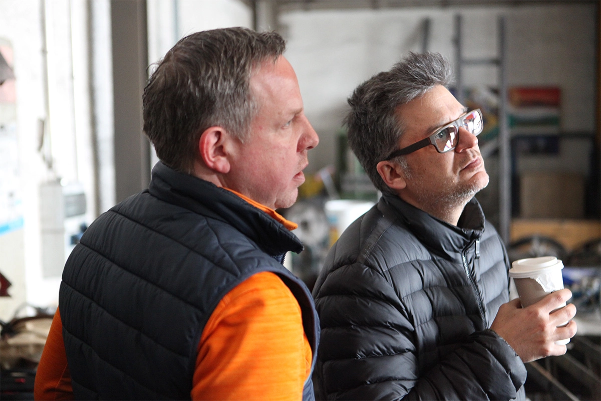 Produktfilm der Filmproduktion Panda Pictures aus München und Ulm für ifm. Produktfilm der Filmproduktion Panda Pictures aus München und Ulm für ifm. Zwei Mitarbeiter der Agentur, einer mit Brille und Kaffeebecher, der andere mit orangefarbener Weste.