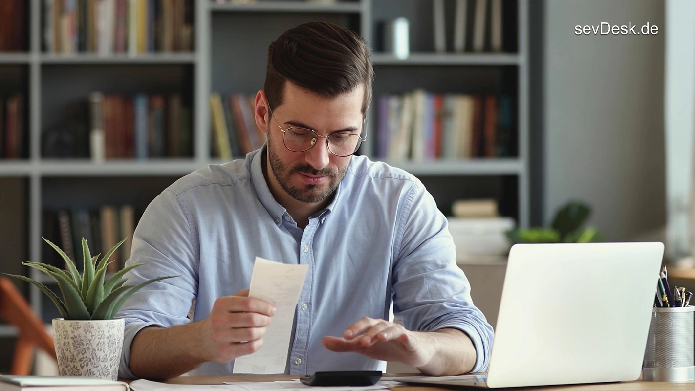 DRTV Spot der Filmproduktion Panda Pictures aus München und Ulm für sevDesk. Nahaufnahme eines Darstellers am Schreibtisch, der Belege sortiert und einen Taschenrechner bedient. Die Beleuchtung suggeriert eine professionelle Inszenierung.