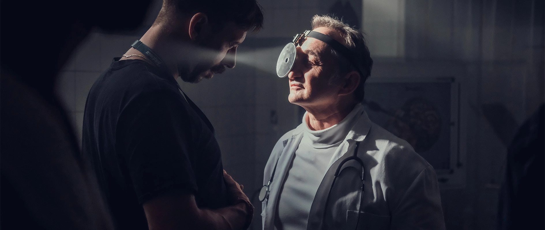 Imagefilm der Filmproduktion Panda Pictures aus München und Ulm für Scheuermann & Heilig. Eine filmische Einstellung, bei der ein Darsteller in Arztkleidung mit Stirnlampe einem anderen Darsteller gegenübersteht, wird gedreht.
