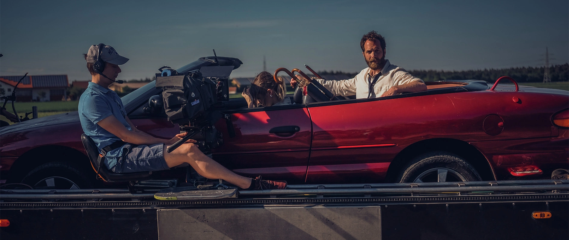 Imagefilm der Filmproduktion Panda Pictures aus München und Ulm für Scheuermann & Heilig. Eine Kamerafahrt mit Darsteller im roten Cabrio, während der Kameramann die Kamera auf dem Kamerawagen bedient.