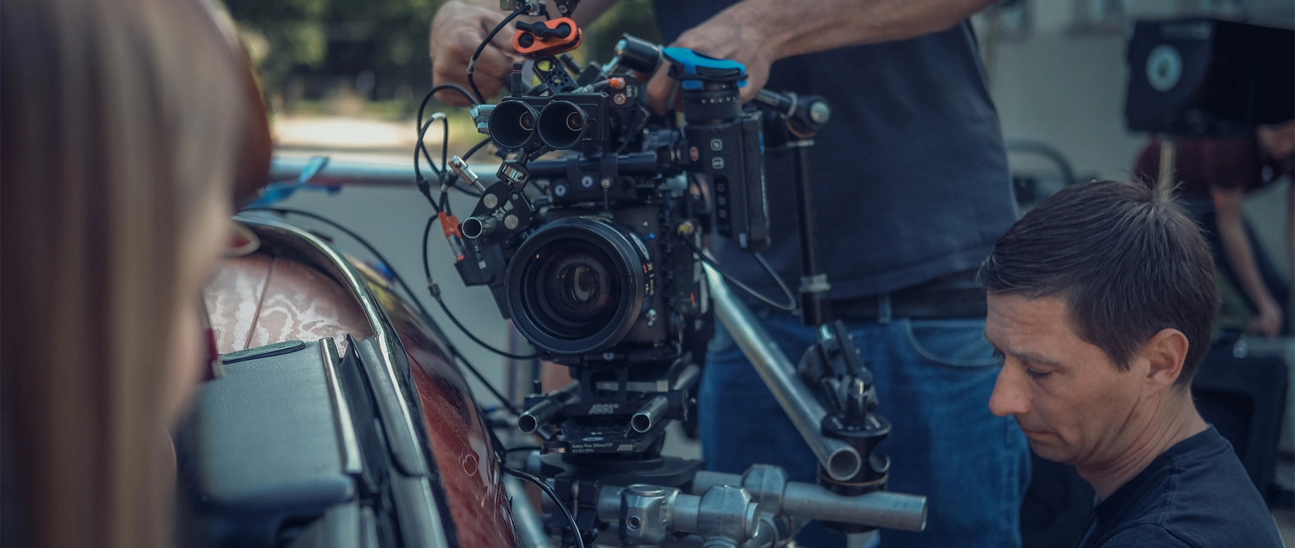 Imagefilm der Filmproduktion Panda Pictures aus München und Ulm für Scheuermann & Heilig. Nahaufnahme eines Kameraoperators, der konzentriert an der Kameraeinstellung für eine Außenszene arbeitet.