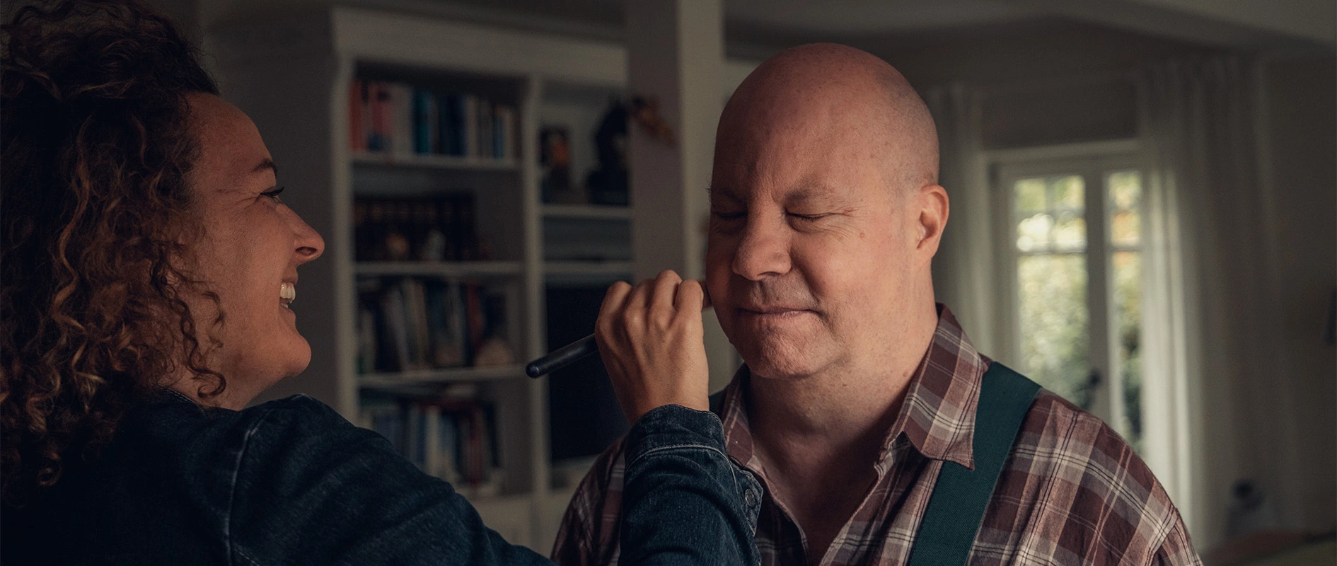 Imagefilm der Filmproduktion Panda Pictures aus München und Ulm für Scheuermann & Heilig. Eine Maskenbildnerin trägt Make-up bei einem Darsteller auf, um ihn für seine Rolle vorzubereiten.