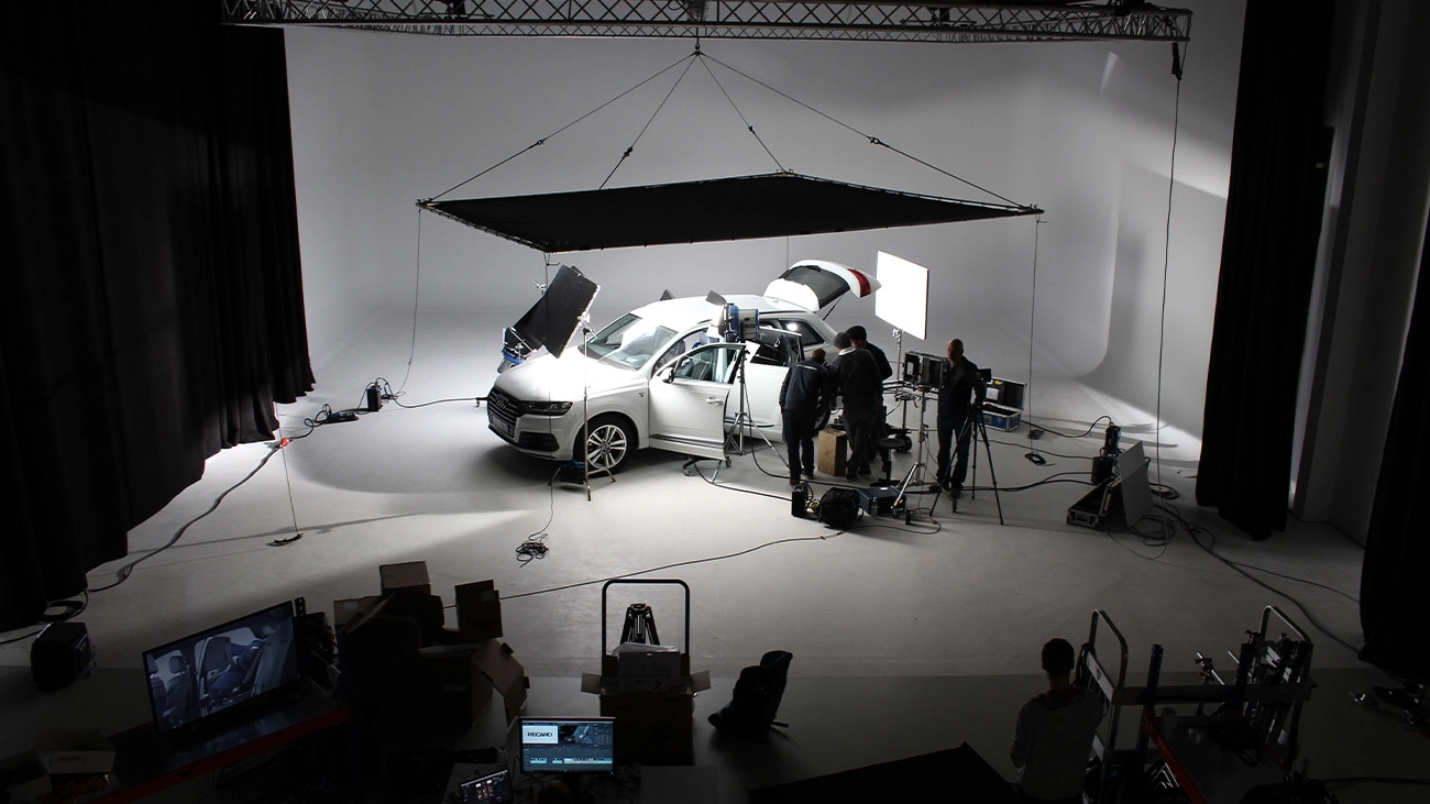 Filmproduktion Panda Pictures aus München und Ulm zum Thema Montagefilm. Ein Filmset mit einem Auto und Crew, das die professionellen Dreharbeiten für einen Montagefilm zeigt.
